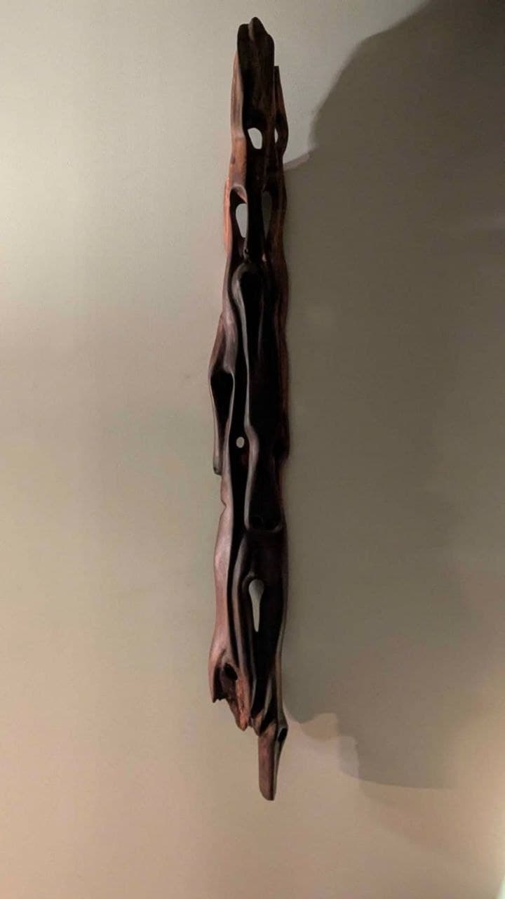 Sculpture verticale en bois — vue d'ensemble depuis l'angle inférieur