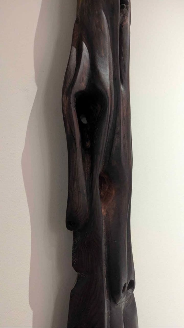 Sculpture verticale en bois sombre — vue d'ensemble centrée